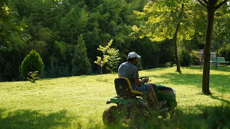 Riding mower cutting a large grass yard